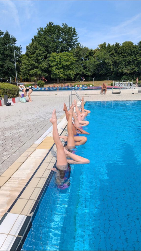 Artistik Swimmer (Synchronschwimmer/-innenI) des ESC Höchstadt zeigen Figuren am Beckenrand vom Freibad